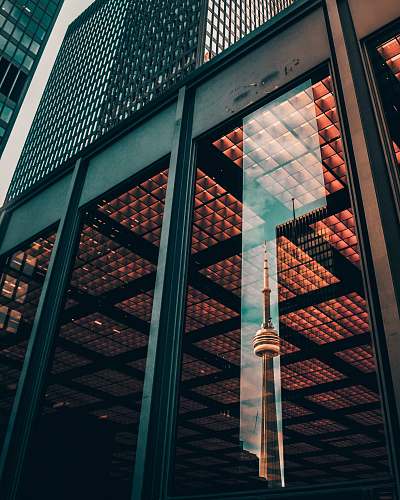 tower glass panel wall of building displaying the reflection of CNN Tower canada