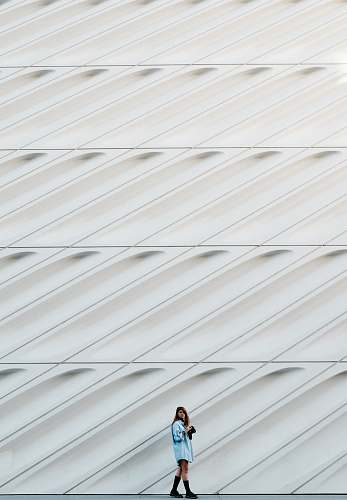 pattern woman standing beside white concrete wall wall