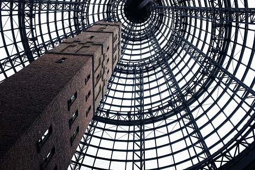 melbourne low-angel photography of gray concrete tower with windows ceiling