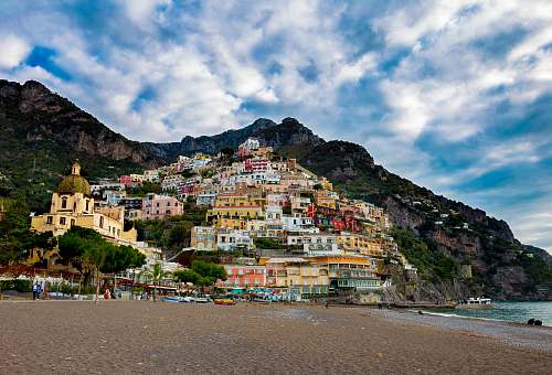 house multicolored village on mountain under white and blue skies building