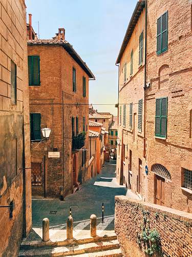 building pathway surrounded by high-rise buildings province of siena