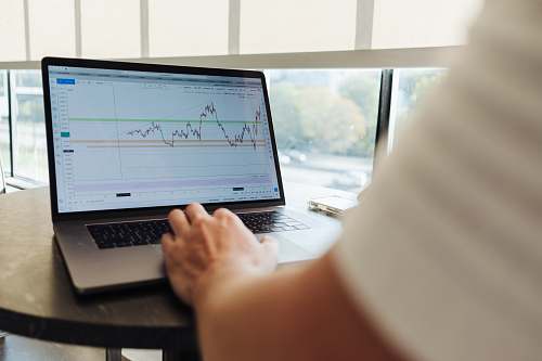 electronics person using MacBook Pro on table pc