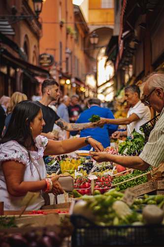 human woman wearing white and red blouse buying some veggies person