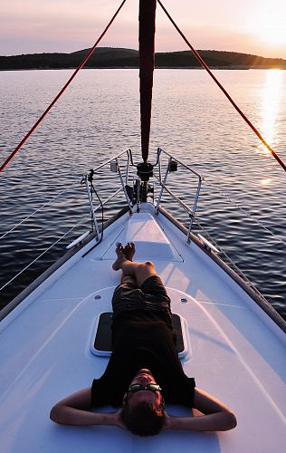 man lying on white boat