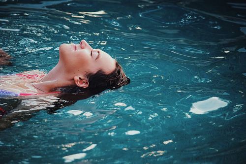 woman floating on body of water