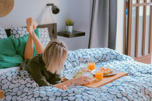 woman lying on bed white holding board