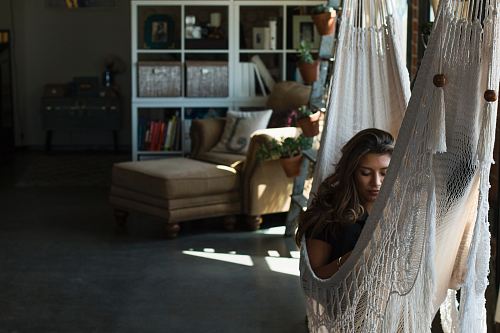 woman on white knit hammock during daytime