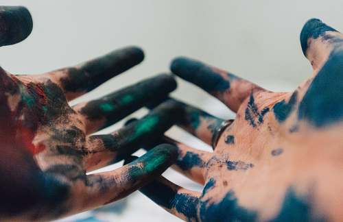 human person hand with green and blue paint paint