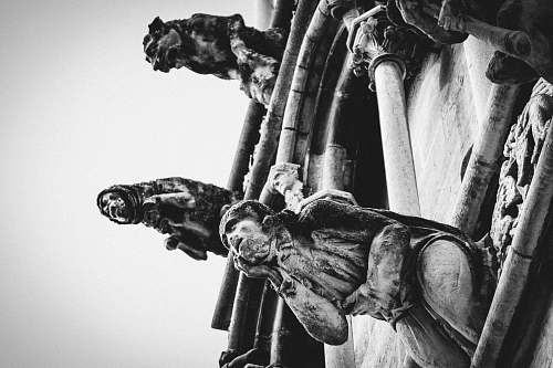statue grayscale photo of three women sitting on brown chairs sculpture