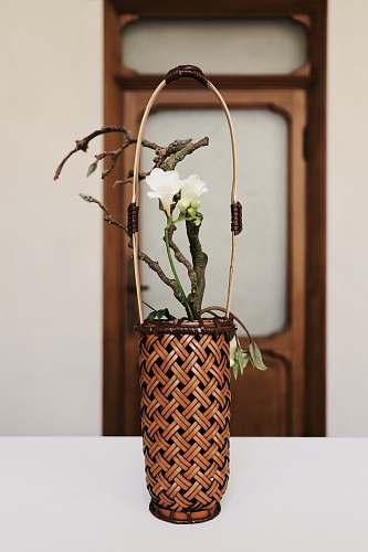 pottery white petaled flower on brown woven basket ornament