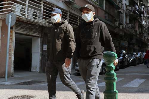 apparel man in black leather jacket and white helmet standing near green water dispenser person