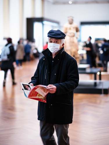 human man in black coat holding book advertisement