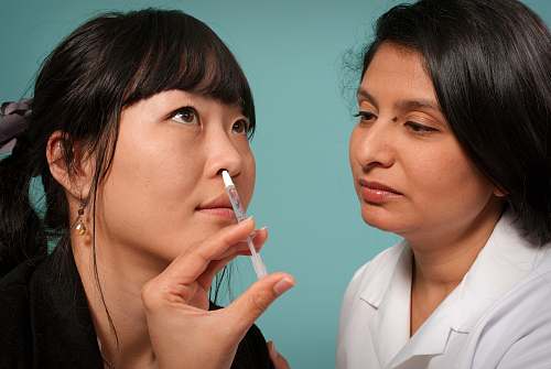 human woman holding syringe near woman wearing black top uncomfortable