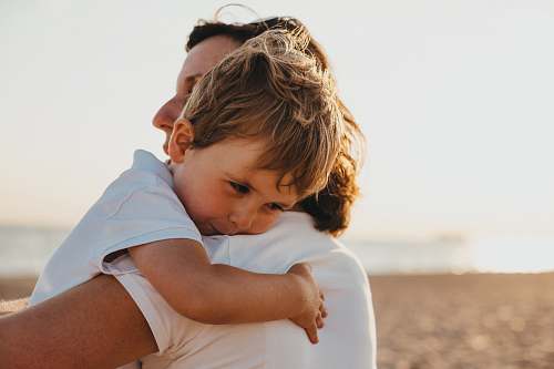 family boy hugging woman during daytime people