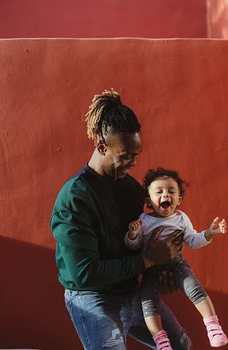 family smiling man carrying child and playing person