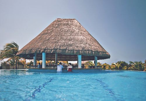 man and woman in blue pool under cottage at daytime
