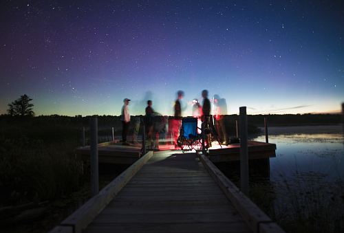 person illustration on brown wooden dock stage photography during nightime