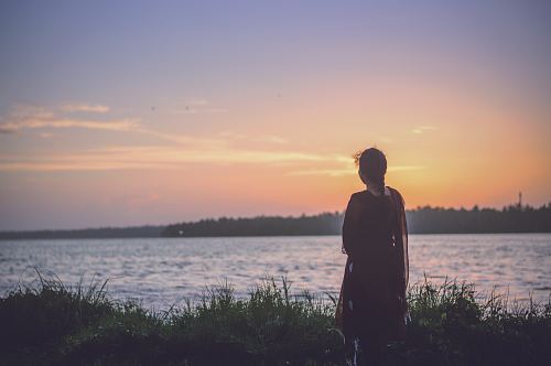 silhouette photography of woman looking at body of water