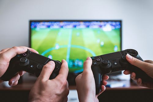 two people playing Sony PS4 game console