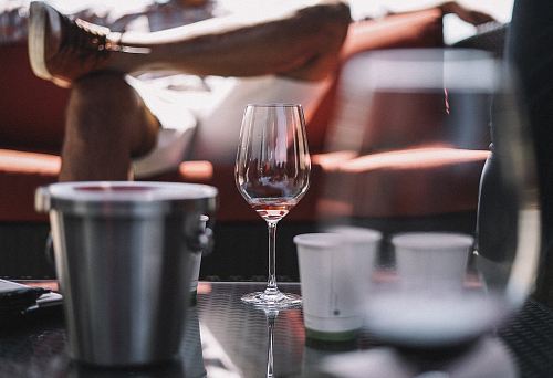 wine glass, ice bucket, and two white cups on table