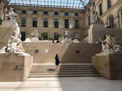 sculpture woman standing on stairs in front of museum paris