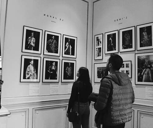 apparel man and woman looking in portraits on wall coat
