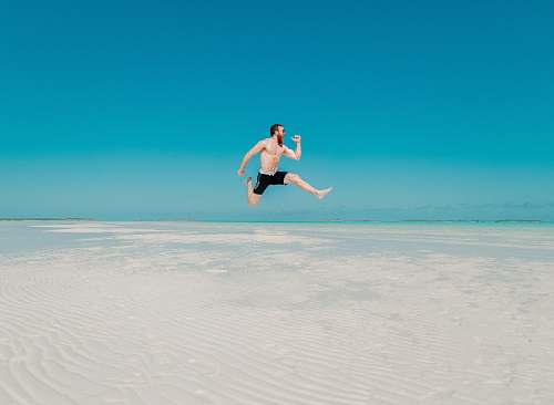 human time lapse photography of man jumping at seashore person