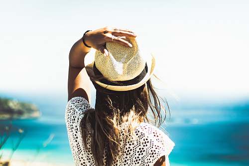 woman woman holding on to her hat hat