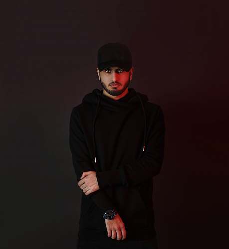 clothing man in black hoodie standing beside wall sleeve