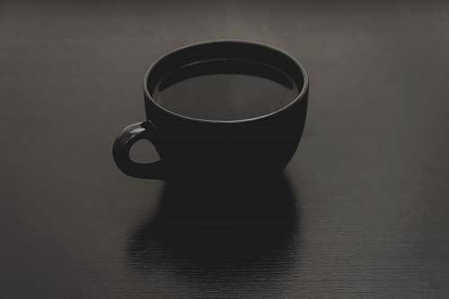 black black ceramic mug with liquid close up photo cup