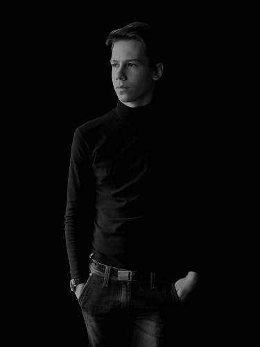 apparel grayscale photography of man with both hands in pocket clothing