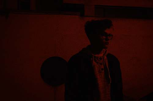 human man in black jacket standing in front of wall person