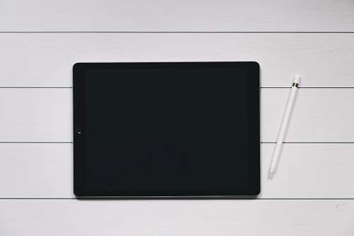 screen space gray iPad with Apple Pencil with white and black pinstriped background tablet