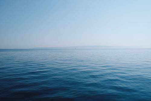 water body of water under blue and white sky at daytime sea