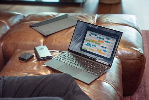 pc black and gray laptop computer on brown leather couch computer