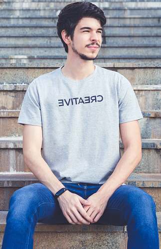 apparel man sitting on concrete stairs pants