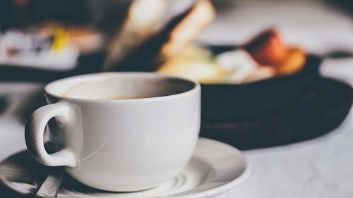 table white ceramic mug on saucer coffee cup