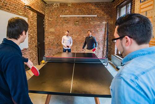 person four men playing table tennis ping pong