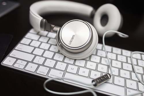 electronics white Menzu corded headphones on Apple Magic keyboard meizu