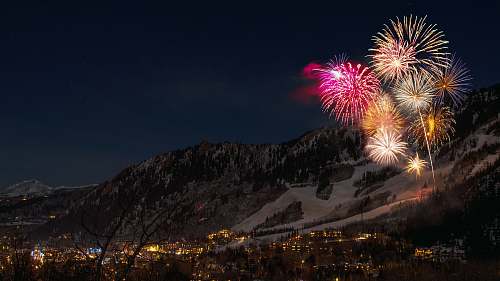 fireworks fireworks display from snow capped mountain during nighttime outdoors