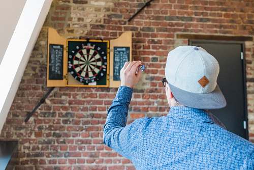 human man in blue dress playing dart apparel
