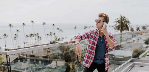 human man in red plaid shirt talking to phone on terrace accessories