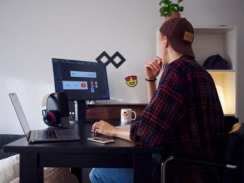 human man sitting near table using computer furniture