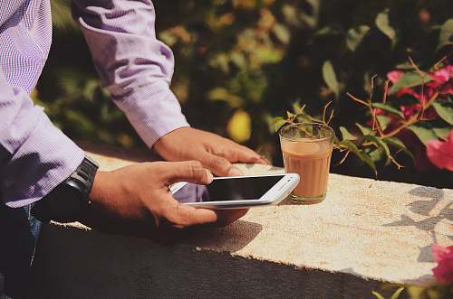 people man using smartphone beside drinking glass drink