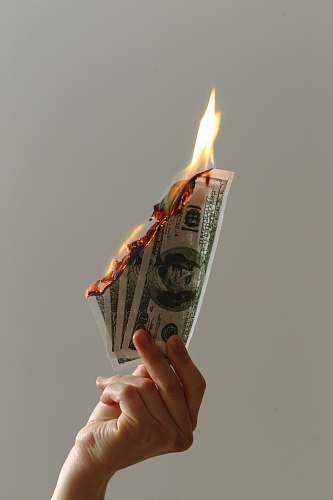 human person holding lighted dollar bills course