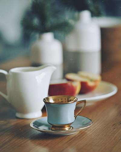 pottery selective focus photography of teacup beside two slices of apple cup
